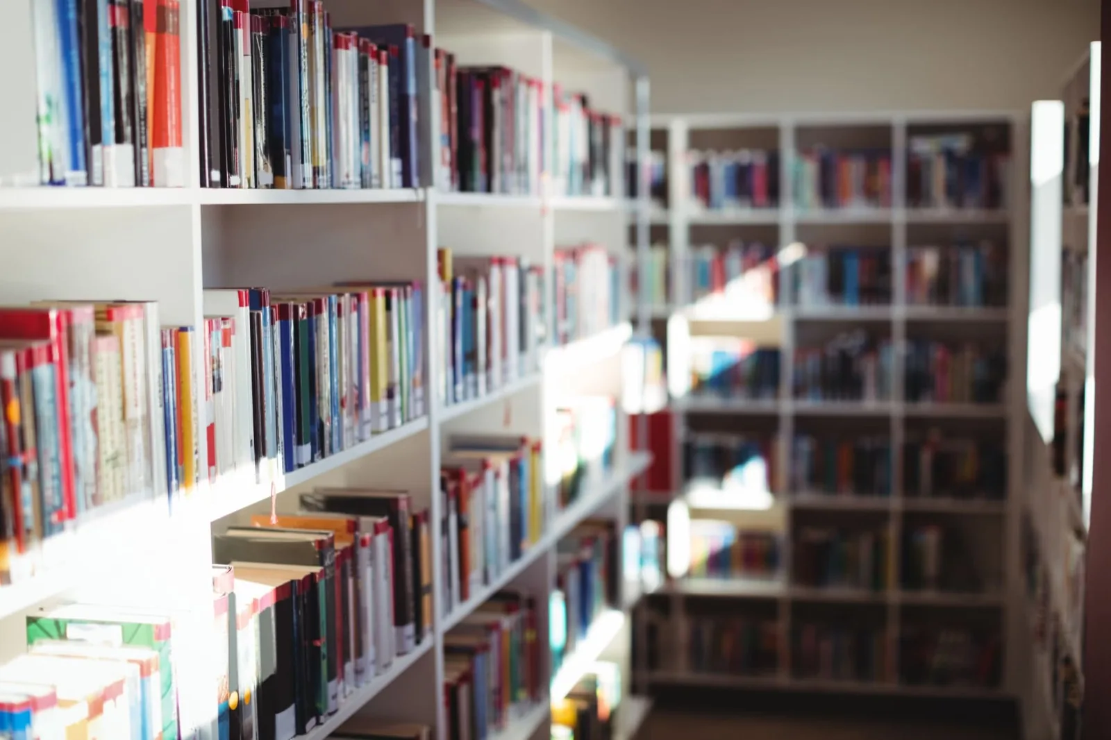 Lange Regale einer öffentlichen Bibliothek voller Bücher — Sinnbild für den Studibuch-Großankauf von Bibliotheken, Antiquariaten und gewerblichen Verkäufern