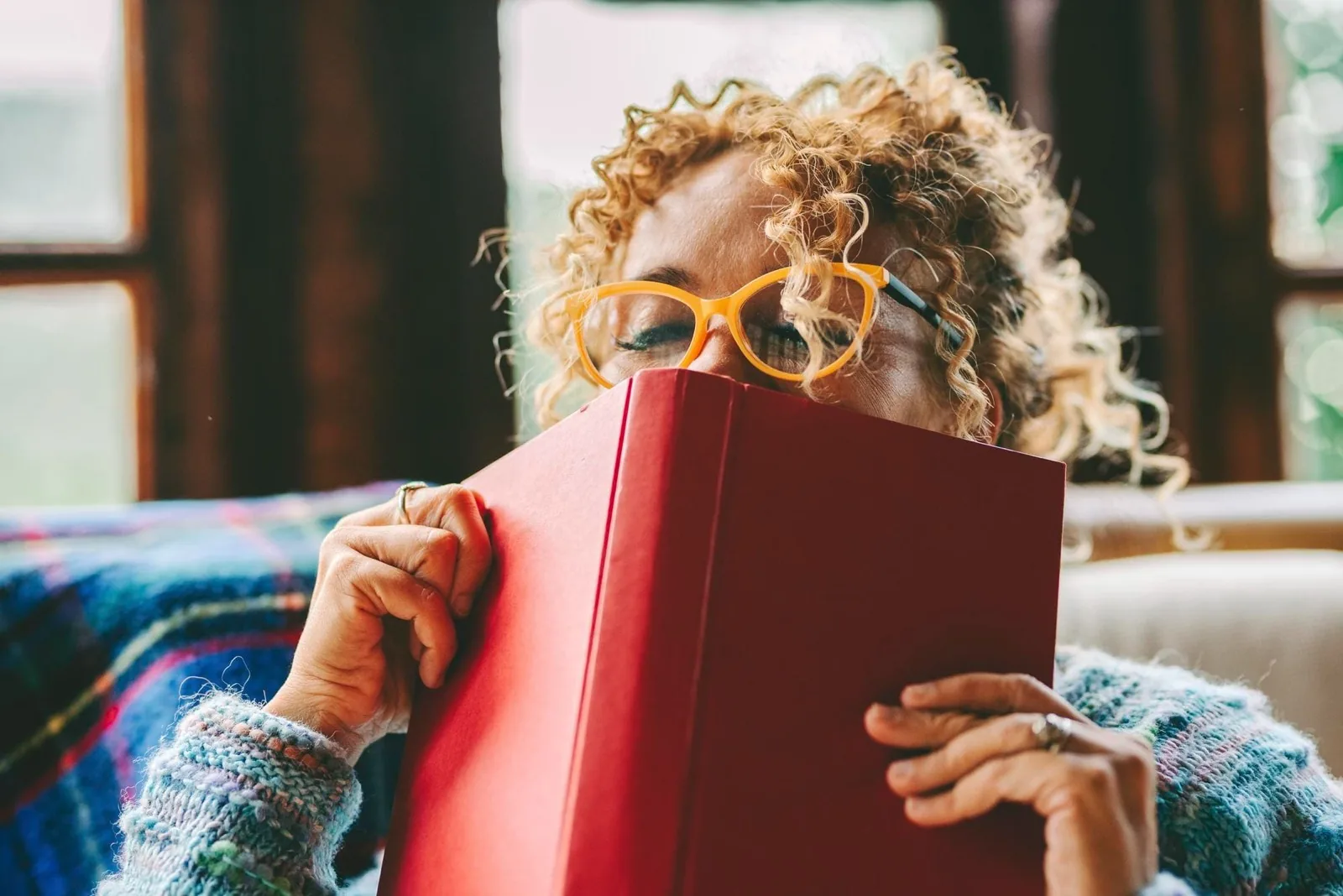 Frau hält ein gebrauchtes rotes Buch in den Händen — Studibuch kauft Bücher fair an und gibt sie über zweitliebe.de in den Kreislauf zurück