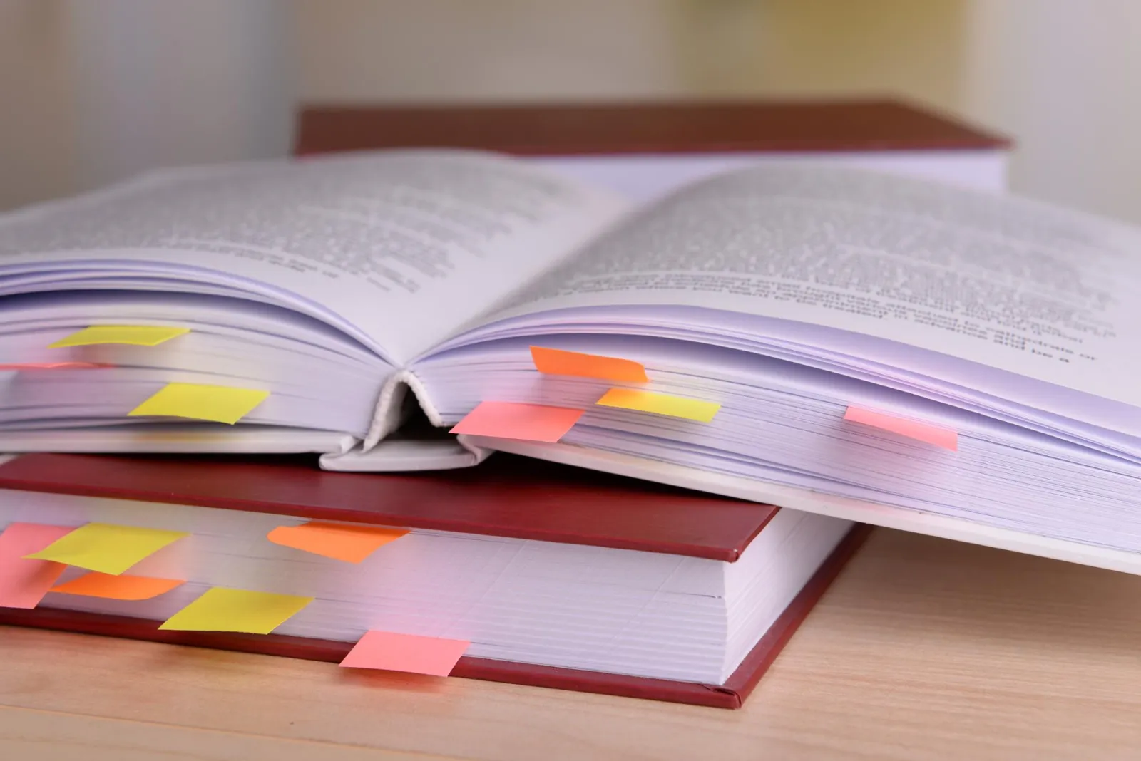 Aufgeschlagene Lehrbücher mit bunten Klebezetteln als Lesezeichen