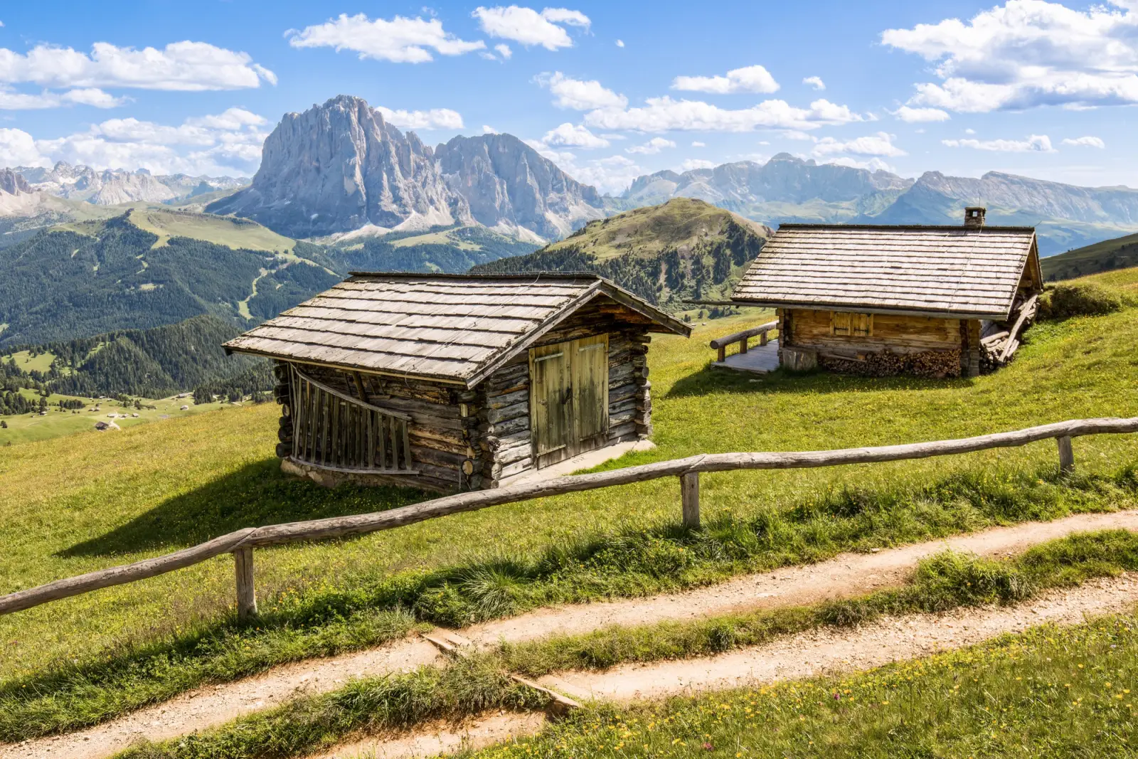 Almhütten auf einer Bergwiese vor den Dolomiten in Österreich