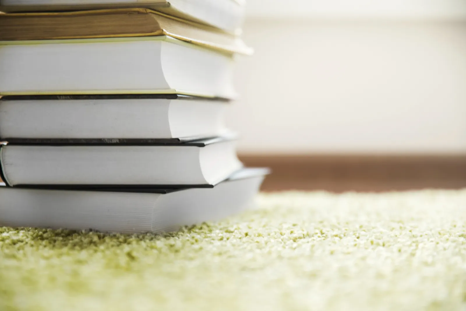 Stapel gebundener Schulbücher auf einem Teppichboden – bereit zum Verkauf